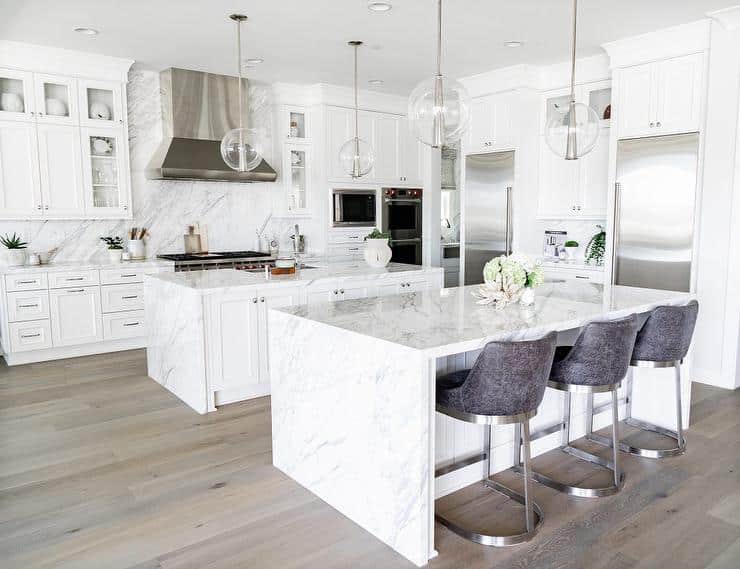 dual kitchen islands with marble waterfall countertops